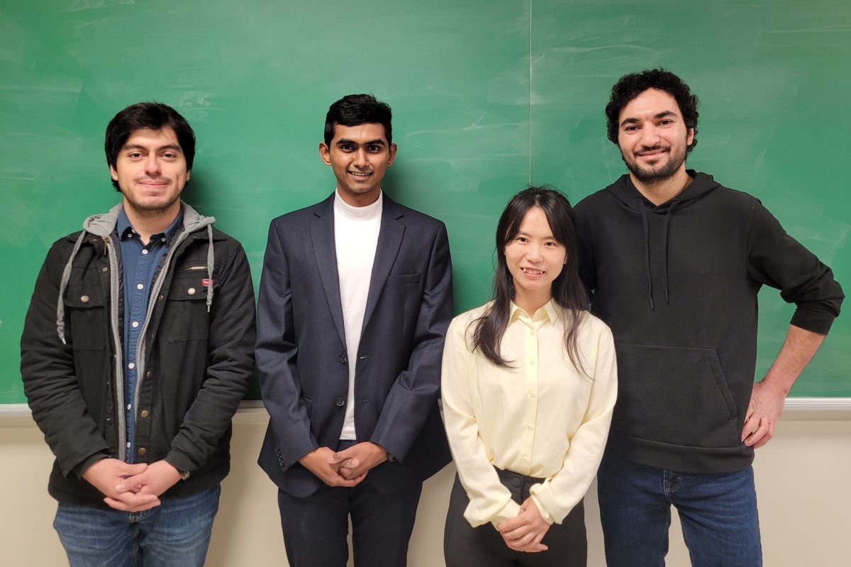 Four students in front of a chalkboard